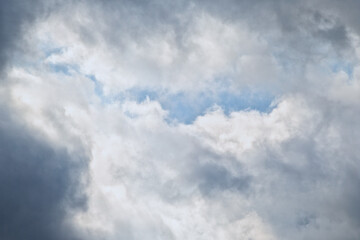 Blue sky in the gap between dark rain clouds