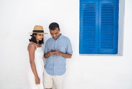 Indian Couple Using Smartphone Outdoors