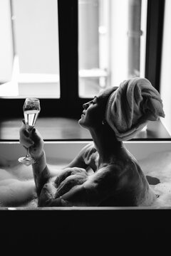 Woman with wine taking bath
