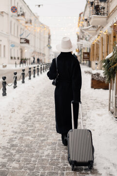 Unrecognizable traveler walking on snowy street

