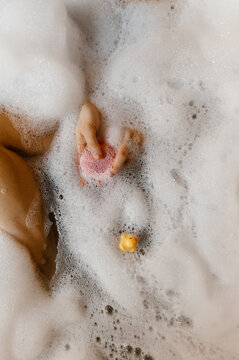 Crop woman with bath bomb and rubber duck

