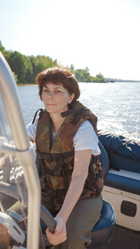 female helmsman driving boat on sunny day