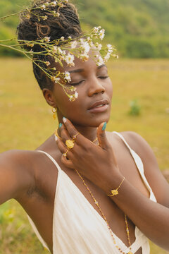 Close up of a black woman touching her face.