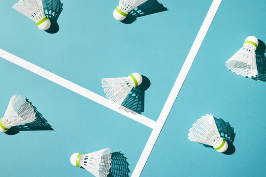 Badminton shuttlecocks scattered on blue background