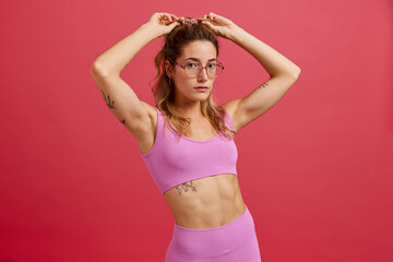 Confident young fit lady looking at camera in studio