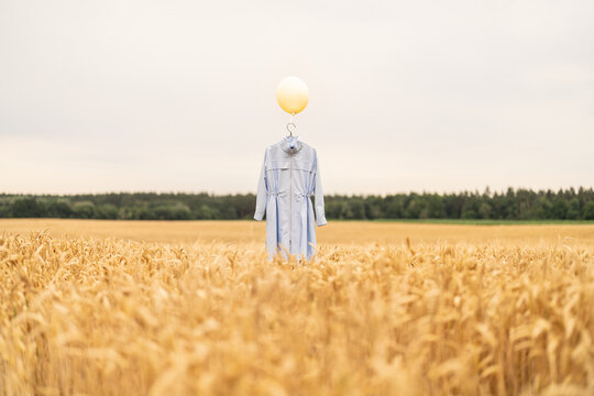 Blue outfit hanging at the hanger with yellow balloon.