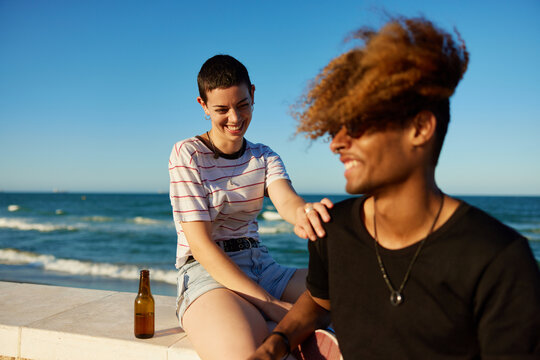 Happy friends with beer on embankment