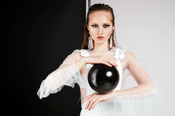 blonde girl in a white bathing suit bodysuit with ruffles in the studio on a white cyclorama with a...