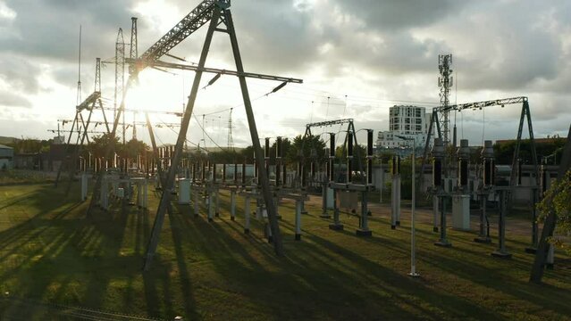 Electrical Power Substation. Electric substation with high voltage poles and transformers at sunset. High voltage electrical switchyard. 