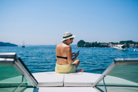 Young Lady Using Smartphone On Boat Floating In Sea