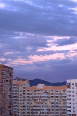 Pink sunset, amazing clouds floating across the sky, panoramic view of urban new buildings, banner, screensaver.