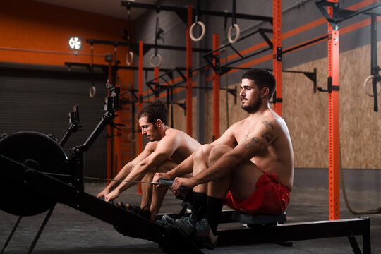Two athletes starting rowing machine workout