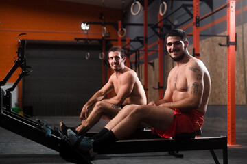 Smiling fit man looking at camera on rowing machine