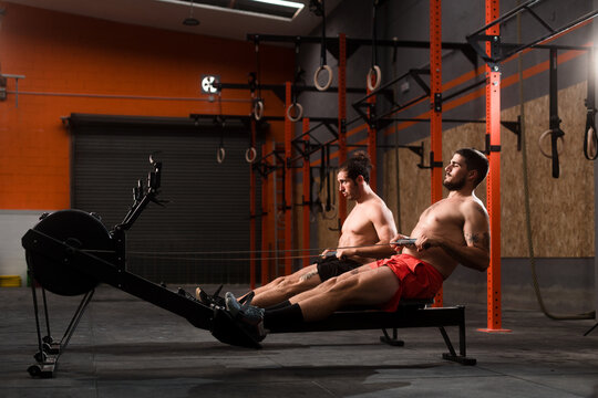 Two athletes using rowing machine workout