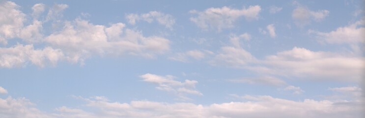 Clear, peaceful blue sky, over which white clouds float slowly like waves Background Banner Screen saver on the monitor.