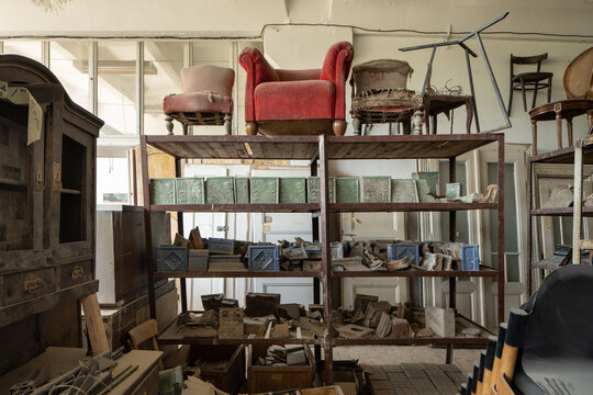 Old armchairs standing at the shelve at the renovation workshop