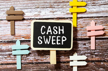 On a white surface are twisted dollars, a notebook and a cardboard sign with the inscription - Cash sweep