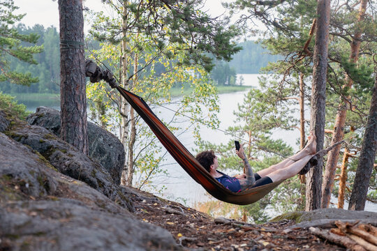 Tattooed man rests in a hammock