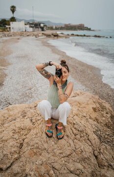 Woman on a beach taking a photo