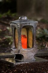 Fototapeta premium funeral lantern in a cemetery at dusk with a burning candle