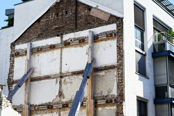 Support of a building wall with wooden struts after demolition of an old building