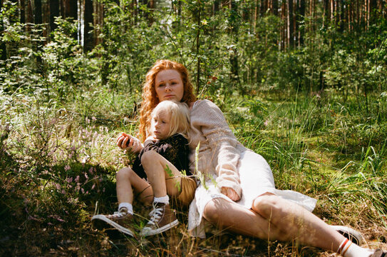 Mother sits with her son on the grass