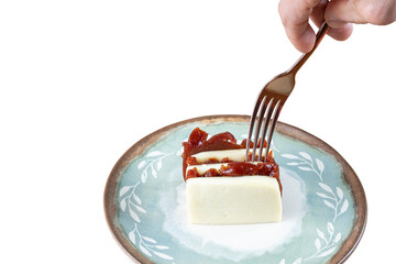 Man picking up with a fork, stacked slices of guava sweet and curd cheese (PNG).