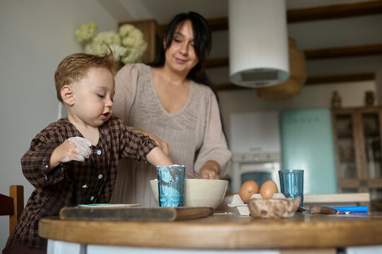 mother baking food in kitchen with her son 