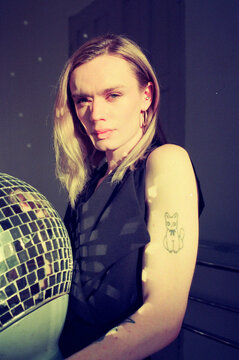 Beautiful trans person with direct sunlight reflect on a ball facet