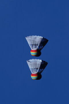Two badminton shuttlecocks on blue background