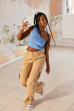 Trendy black woman dancing in grungy room
