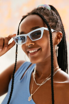 Cheerful black female adjusting sunglasses