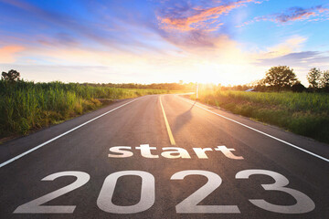 Start 2023 written on highway road in the middle of empty asphalt road of asphalt road at...