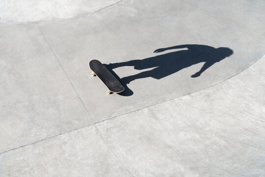 Invisible skateboarder stands on a skateboard in a skate park.