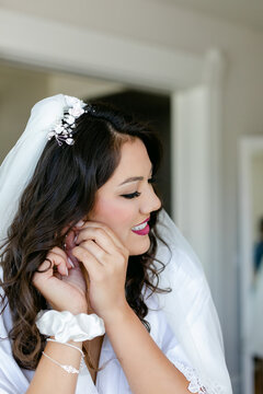 Bride Putting on Earrings