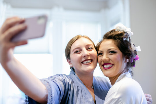 Bride and Bridesmaid Smiling Taking Selfie