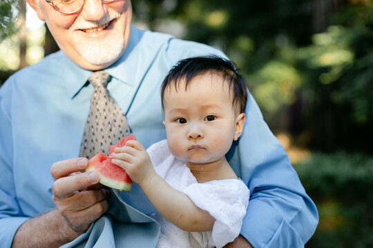 Smiling Grandpa Holding Baby Eating Watermelon