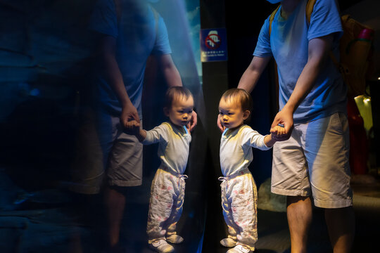 Asian baby visiting the aquarium with father