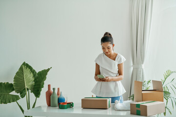 Female small business owner using mobile app on smartphone