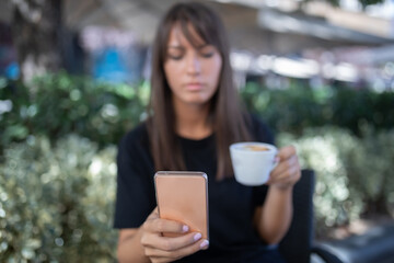 Morning in cafe - attractive woman in black drinkin coffe and make selfie photo for social networks