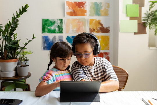 Kids sharing tablet in painting studio