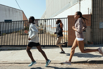 African American joggers running on sidewalk