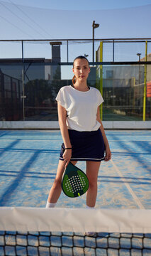 Confident sportswoman with padel racket on court