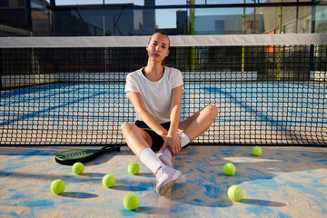 Padel player sitting on sports ground