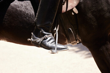 Rider's boot sitting in a horse stirrup 