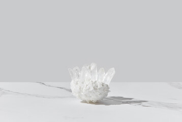 Healing white quartz crystal on marble background