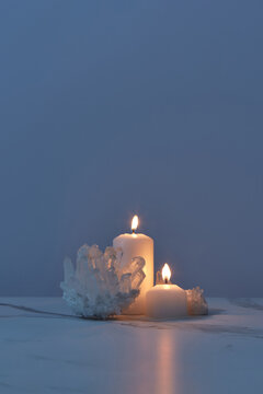 Shiny quartz crystals with candles burning in dark