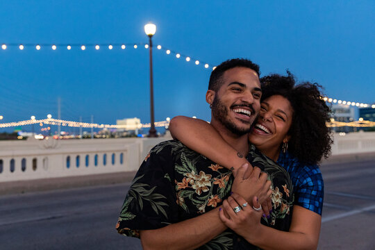 Young Black couple hugging together  out in city at night