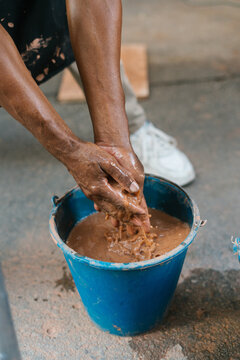 Faceless person washing clay off hands