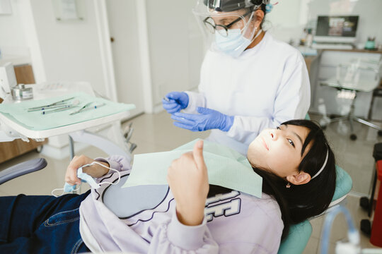 Female dentist examining child teeth in dentist's office